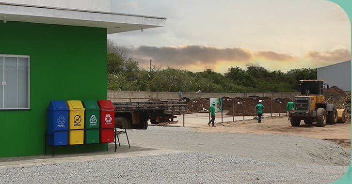 Fachada verde da unidade da Mais Ambiental com coletores de coleta seletiva e equipe em operação